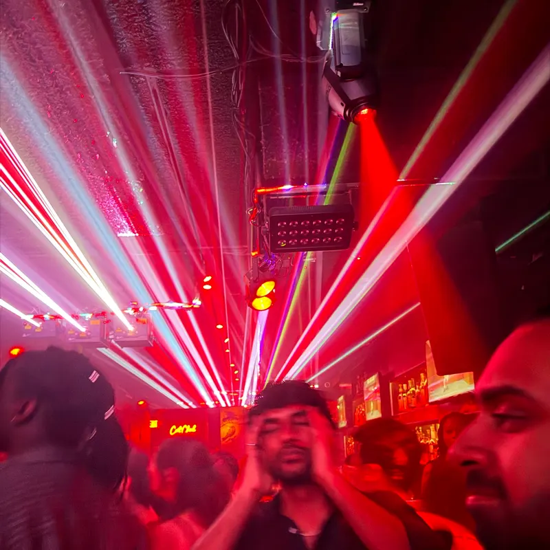 Red lasers sweeping over a crowd in a club