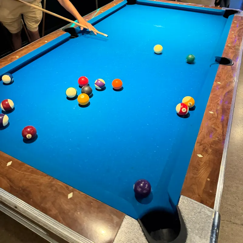 Billiard balls scattered across a blue pool table