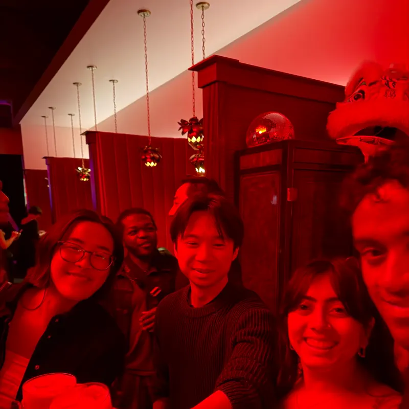 A group selfie in a restaurant lit entirely in red